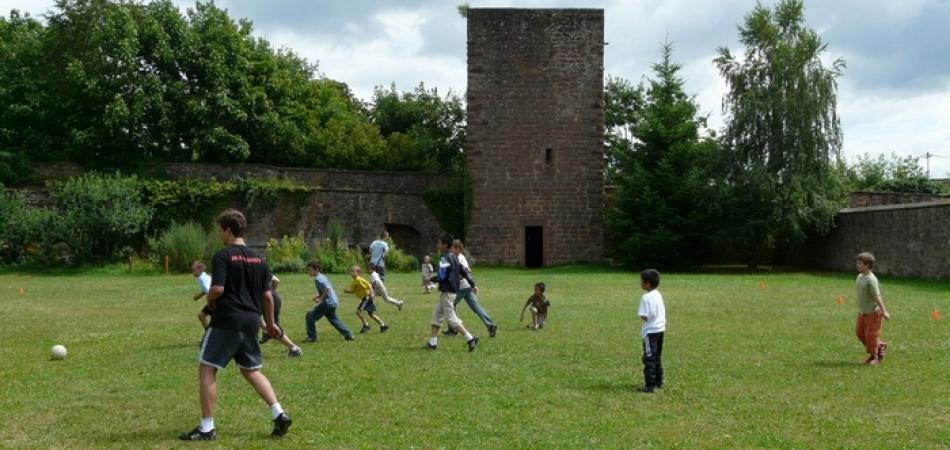 Neuwiller Partie de football devant la tour médiévale